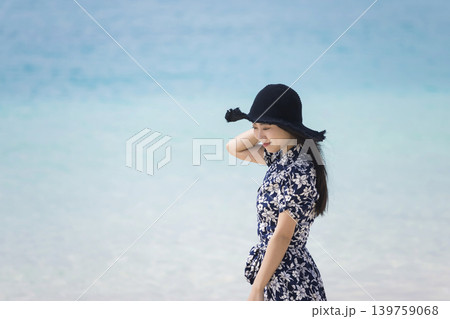 海辺を歩く麦わら帽子を被った若い女性 139759068