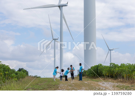 Family with daughter walking on field on wind farm. Family with daughter walking on field on wind farm. 139759280
