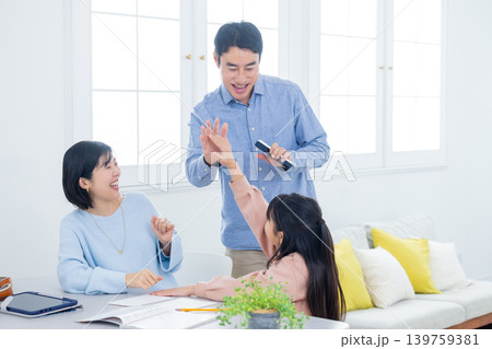 自宅学習をする小学生と家族　 139759381