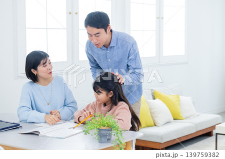 自宅学習をする小学生と家族　 139759382