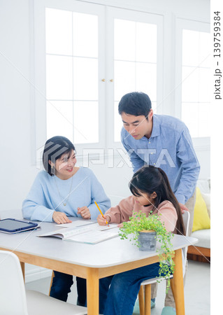 自宅学習をする小学生と家族　 139759384