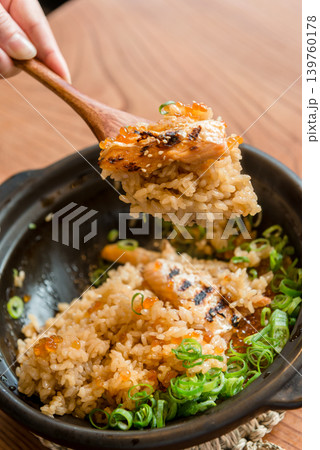 土鍋で炊いた鮭といくらの親子御飯を木のスプーンですくい上げる風景 土鍋で炊いた鮭といくらの親子御飯を木のスプーンですくい上げる風景 139760178