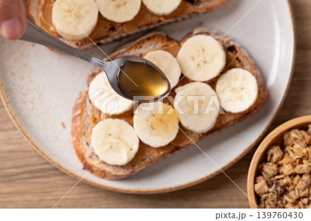 Cranberry sourdough bread with peanut butter, banana slices, granola and honey  139760430