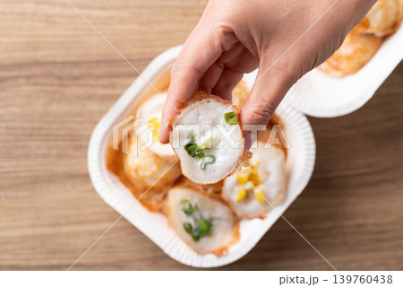 Eating Thai coconut pancakes (Khanom Krok) with spring onion topping Eating Thai coconut pancakes (Khanom Krok) with spring onion topping 139760438