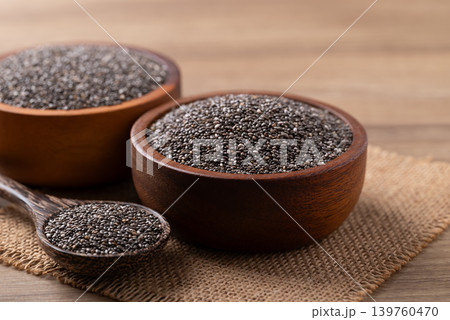 Healthy organic chia seeds in a wooden bowl and spoon on a wooden background Healthy organic chia seeds in a wooden bowl and spoon on a wooden background 139760470