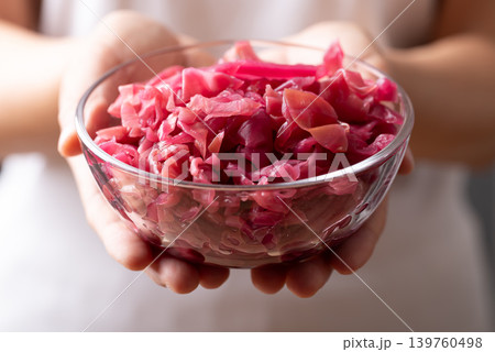 Red cabbage sauerkraut in a glass bowl holding by woman hand, healthy fermented probiotic food Red cabbage sauerkraut in a glass bowl holding by woman hand, healthy fermented probiotic food 139760498