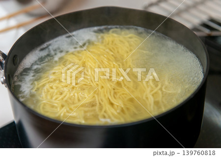 鍋の中で茹でられる中華麺のクローズアップ　調理シーン 139760818