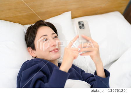 ベッドでスマホを操作する日本人女性 139761294