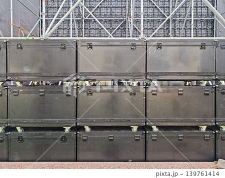 Stacked professional speaker cabinets on wheels in front of LED screen Stacked professional speaker cabinets on wheels in front of LED screen 139761414