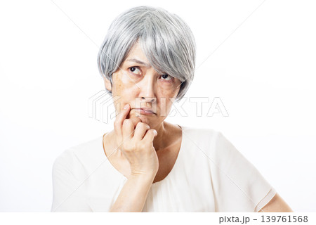 難しい表情をして考える高齢者の女性 139761568