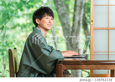 温泉旅館の部屋でパソコンで仕事をする浴衣姿の男性 温泉旅館の部屋でパソコンで仕事をする浴衣姿の男性 139762138
