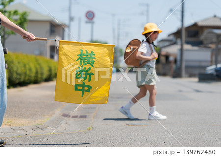 登下校中の小学生と交通安全見守りの旗 登下校中の小学生と交通安全見守りの旗 139762480