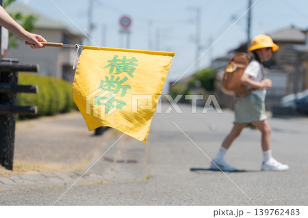 登下校中の小学生と交通安全見守りの旗 139762483