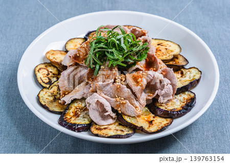 テーブルの上に置かれた焼きなすの豚しゃぶのせ 139763154