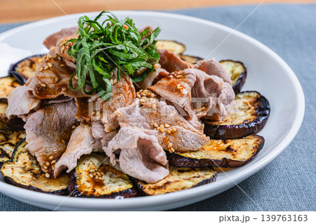 テーブルの上に置かれた焼きなすの豚しゃぶのせ 139763163