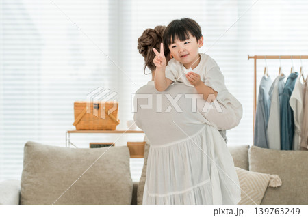家で母親に抱っこされるおやつを食べるピースをする子ども,男の子(ファミリー,親子,家族) 家で母親に抱っこされるおやつを食べるピースをする子ども,男の子(ファミリー,親子,家族) 139763249