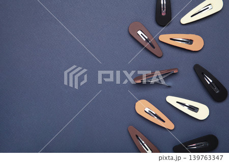 Colored pastel hair clips on dark blue background. 139763347