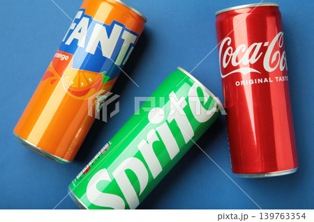 Mykolaiv, Ukraine - March 25, 2026: Iron cans of Coca Cola, Fanta and Sprite drink on blue background. Mykolaiv, Ukraine - March 25, 2026: Iron cans of Coca Cola, Fanta and Sprite drink on blue background. 139763354