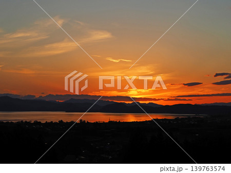 猪苗代湖対岸に夕日が沈み、オレンジ色に輝く雲と湖面が印象的で綺麗だ。 猪苗代湖対岸に夕日が沈み、オレンジ色に輝く雲と湖面が印象的で綺麗だ。 139763574