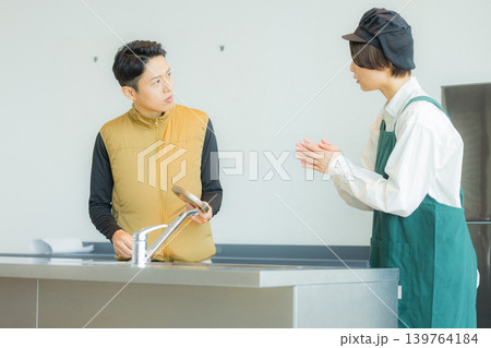 資料を見ながら打ち合わせする空調服の職人の男性 139764184