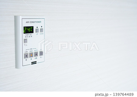 夏の節電と温度調節。壁に設置されたエアコンのリモコンパネルのクローズアップ 139764489