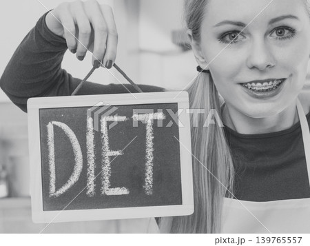 Happy woman holding board with diet sign Happy woman holding board with diet sign 139765557