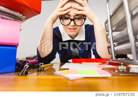 Depressed businesswoman sitting at desk Depressed businesswoman sitting at desk 139767150