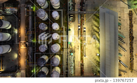 Aerial view of tanker truck industrial oil distribution at night with tanker truck, Fuel reserves oil refinery infrastructure, Fuel distribution center energy product fuel storage tank. Aerial view of tanker truck industrial oil distribution at night with tanker truck, Fuel reserves oil refinery infrastructure, Fuel distribution center energy product fuel storage tank. 139767257