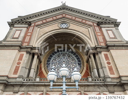 An low-angle view the magnificent Victorian architecture of Alexandra Palace Great Hall facade. The structure is an exquisite tapestry of pale cream and rich terracotta brickwork, striking a perfect An low-angle view the magnificent Victorian architecture of Alexandra Palace Great Hall facade. The structure is an exquisite tapestry of pale cream and rich terracotta brickwork, striking a perfect 139767432