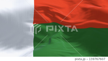 Malagasy flag of Madagascar waving in wind on clear blue sky. 3D render Malagasy flag of Madagascar waving in wind on clear blue sky. 3D render 139767607