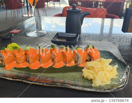 Gourmet Sushi Roll with Spicy Sauce and Pickled Ginger on Elegant Ceramic Plate Gourmet Sushi Roll with Spicy Sauce and Pickled Ginger on Elegant Ceramic Plate 139768674