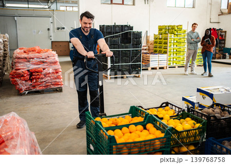 Male worker moving fresh fruit crates in warehouse Male worker moving fresh fruit crates in warehouse 139768758