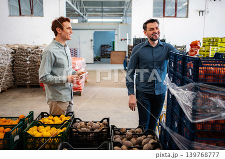 Workers checking produce in a food distribution warehouse Workers checking produce in a food distribution warehouse 139768777