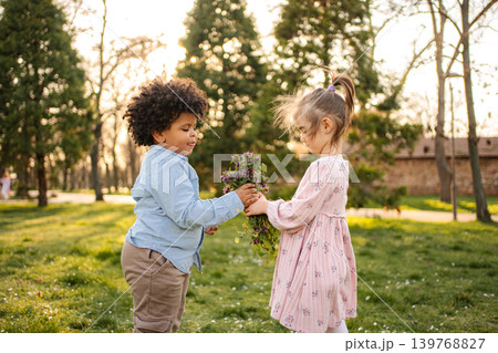 Children sharing flowers in park expressing friendship Children sharing flowers in park expressing friendship 139768827