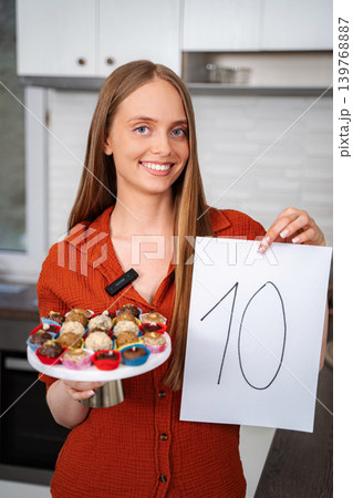 Woman holding tray of desserts and number ten sign Woman holding tray of desserts and number ten sign 139768887
