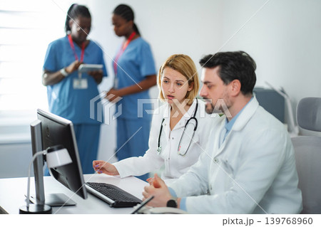 Medical team collaborating online in hospital using computer Medical team collaborating online in hospital using computer 139768960