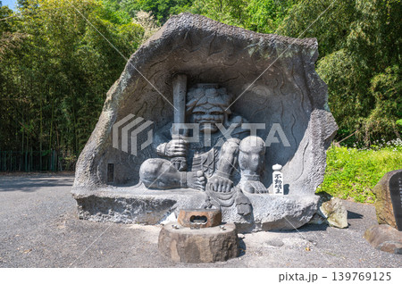 強い表情の不動明王石像と新緑の風景 139769125