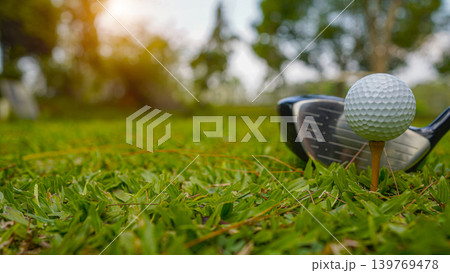 Golf clubs and balls on a green lawn in a beautiful golf course with morning sunshine. Golf clubs and balls on a green lawn in a beautiful golf course with morning sunshine. 139769478