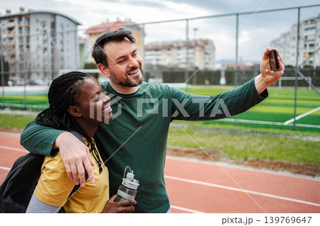 Diverse couple smiling, taking selfie after outdoor workout 139769647