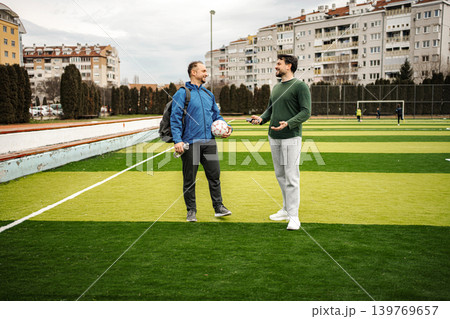 Two friends talking on a football field before game Two friends talking on a football field before game 139769657