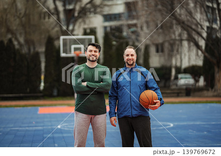 Two friends posing on outdoor basketball court 139769672