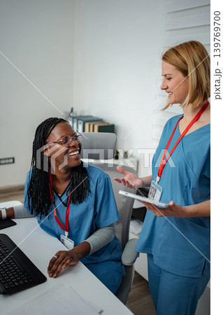 Two nurses discussing patient information using a digital tablet Two nurses discussing patient information using a digital tablet 139769700
