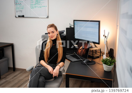 Young adult woman sitting at ergonomic home office desk Young adult woman sitting at ergonomic home office desk 139769724