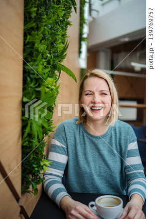 Happy woman laughing enjoying coffee in cafe 139769757