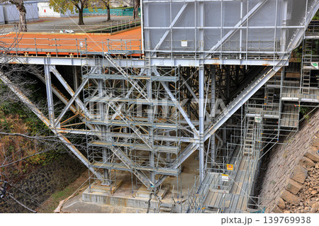 Covered facade of a reconstruction building, Scaffolding with safety nets during renovation building. Covered facade of a reconstruction building, Scaffolding with safety nets during renovation building. 139769938