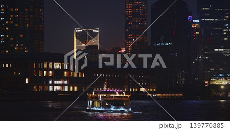 Nightscape of a Vibrant City with a Boat on the Water and Modern Buildings Nightscape of a Vibrant City with a Boat on the Water and Modern Buildings 139770885