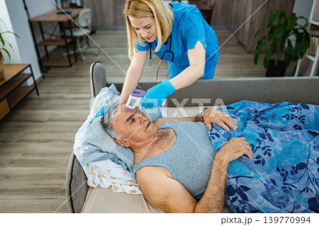 Caring nurse monitors elderly patient s health at home 139770994