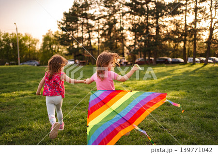 Children enjoy flying a colorful kite on a sunny afternoon Children enjoy flying a colorful kite on a sunny afternoon 139771042