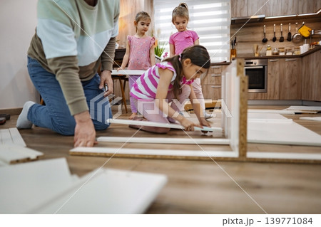 Family builds furniture together in a cozy modern kitchen Family builds furniture together in a cozy modern kitchen 139771084