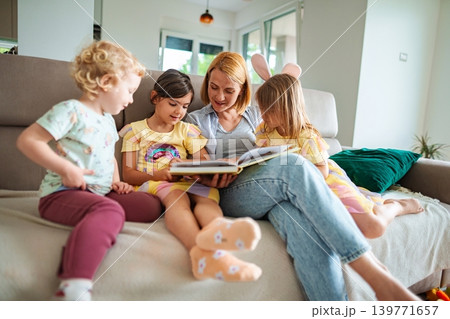 Enjoying storytime together in a cozy living room Enjoying storytime together in a cozy living room 139771657